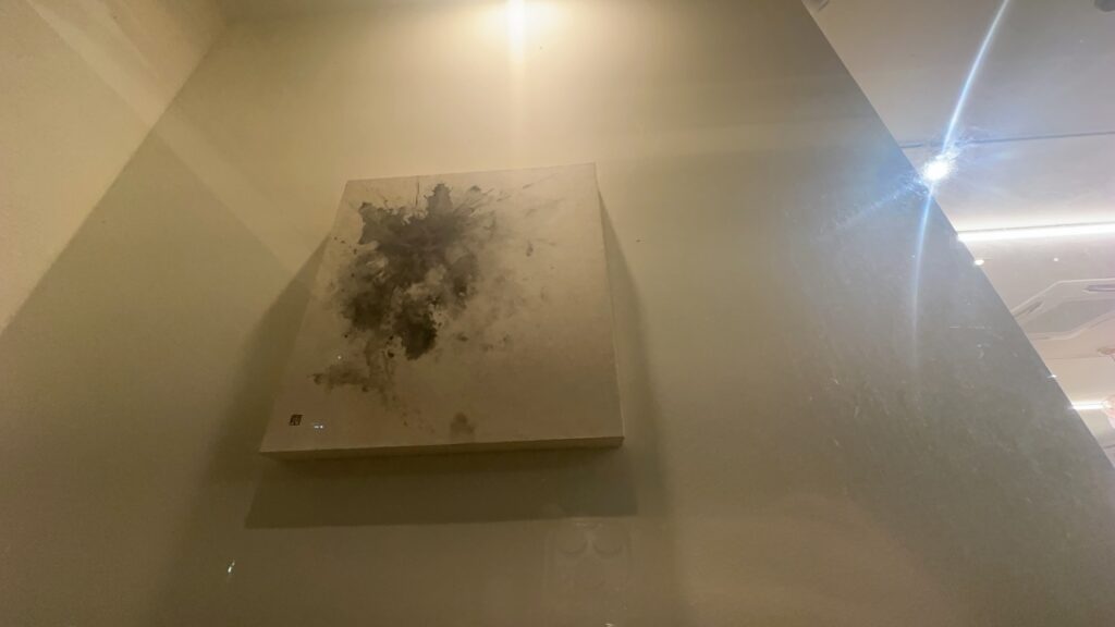 조명 아래 벽에 걸린 채색 추상 캔버스 작품